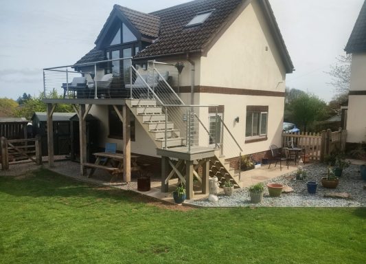 Constructed balcony with access stairs and stainless steel handrail components.